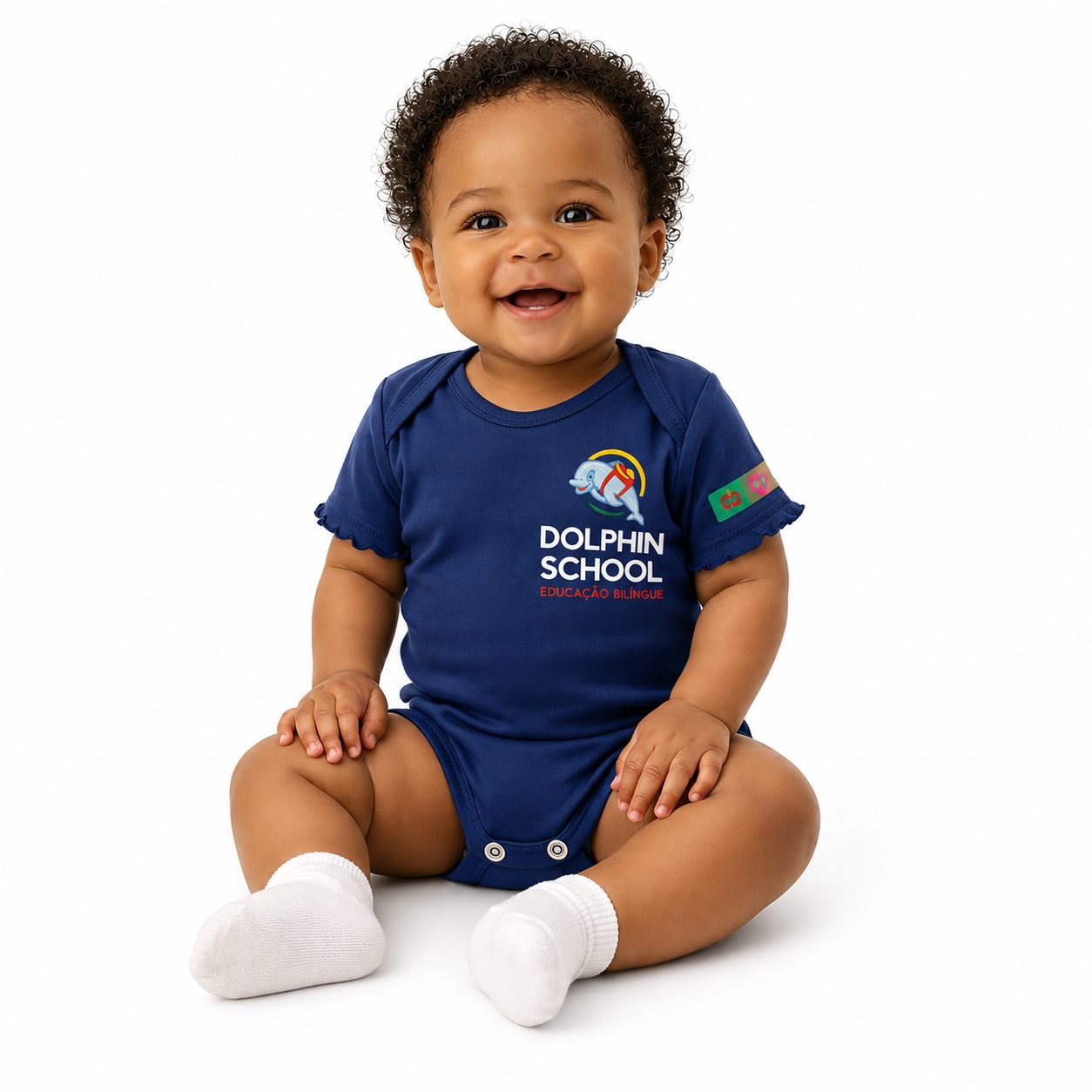 Bebê sorridente usando body azul marinho do uniforme escolar Dolphin School Educação Bilíngue - Referência Uniformes